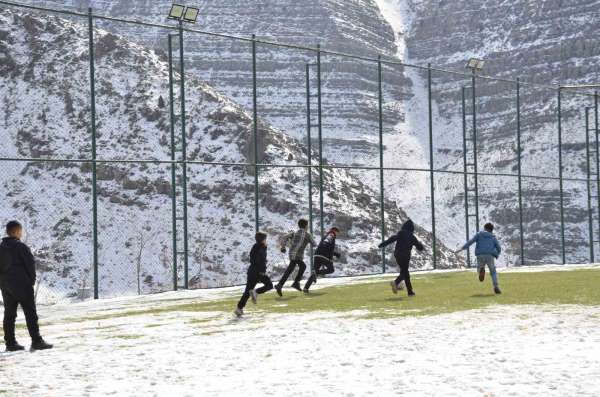 Şırnak'ta çocuklar futbol aşkına karlı yolları aşıp halı sahada top oynuyor