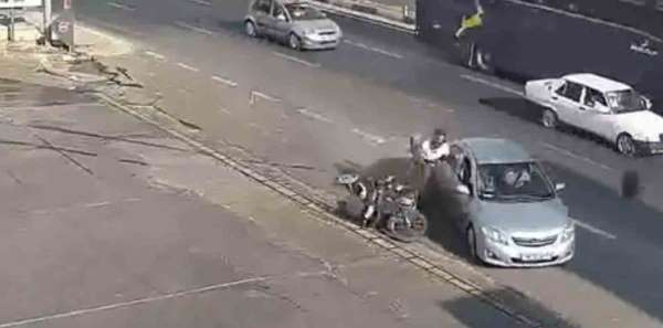 Kazada motosiklet sürücüsü çarpıştığı otomobilin kapısına tutunup sonra yere düştü