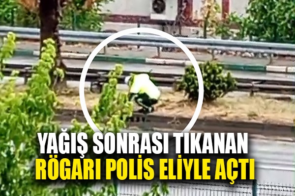Yağış sonrası tıkanan rögarı açan polis örnek bir davranış sergiledi