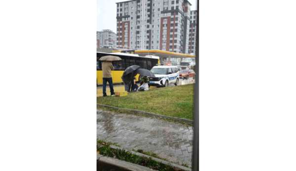 Yağmur altında ıslanan yaralıya trafik polisi şemsiye tuttu